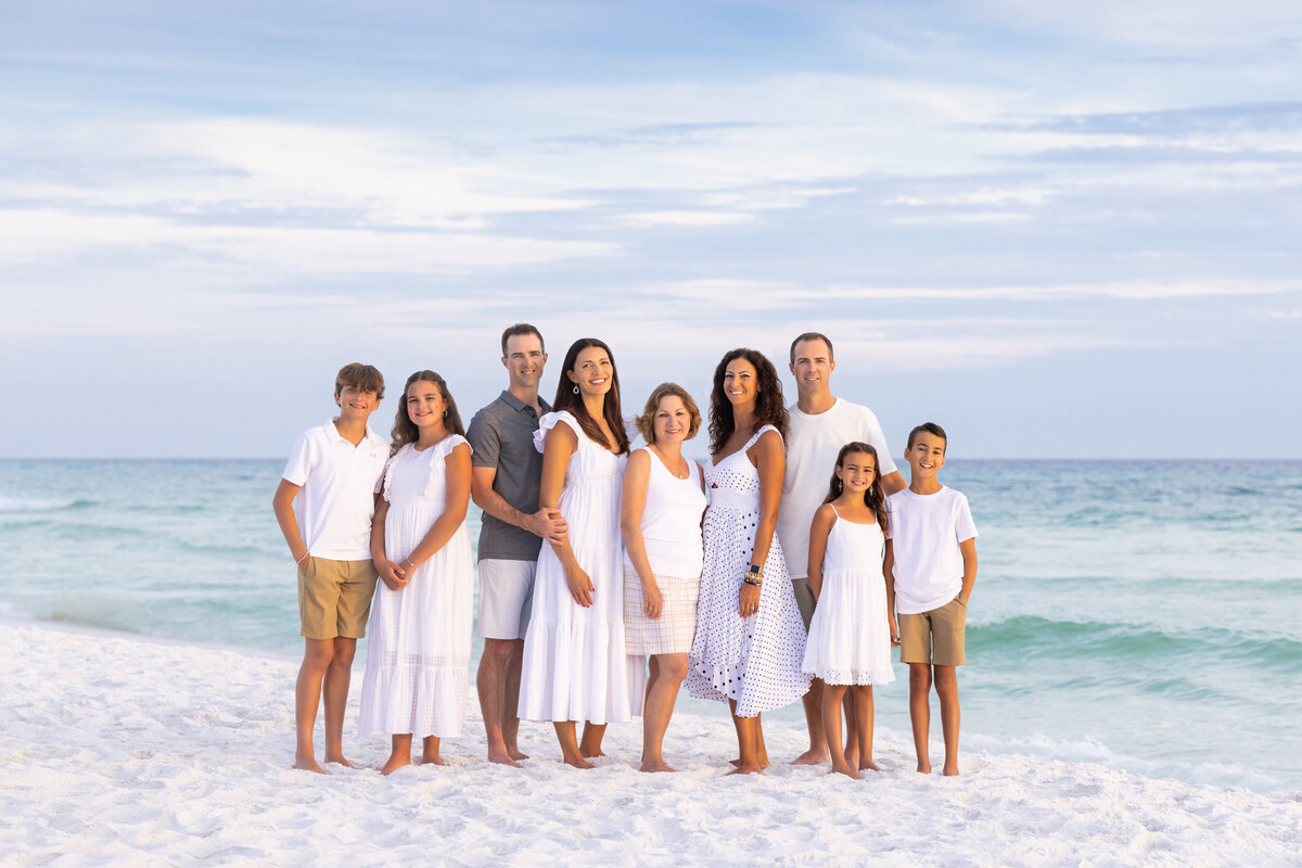 A large family smiling together at the beach
