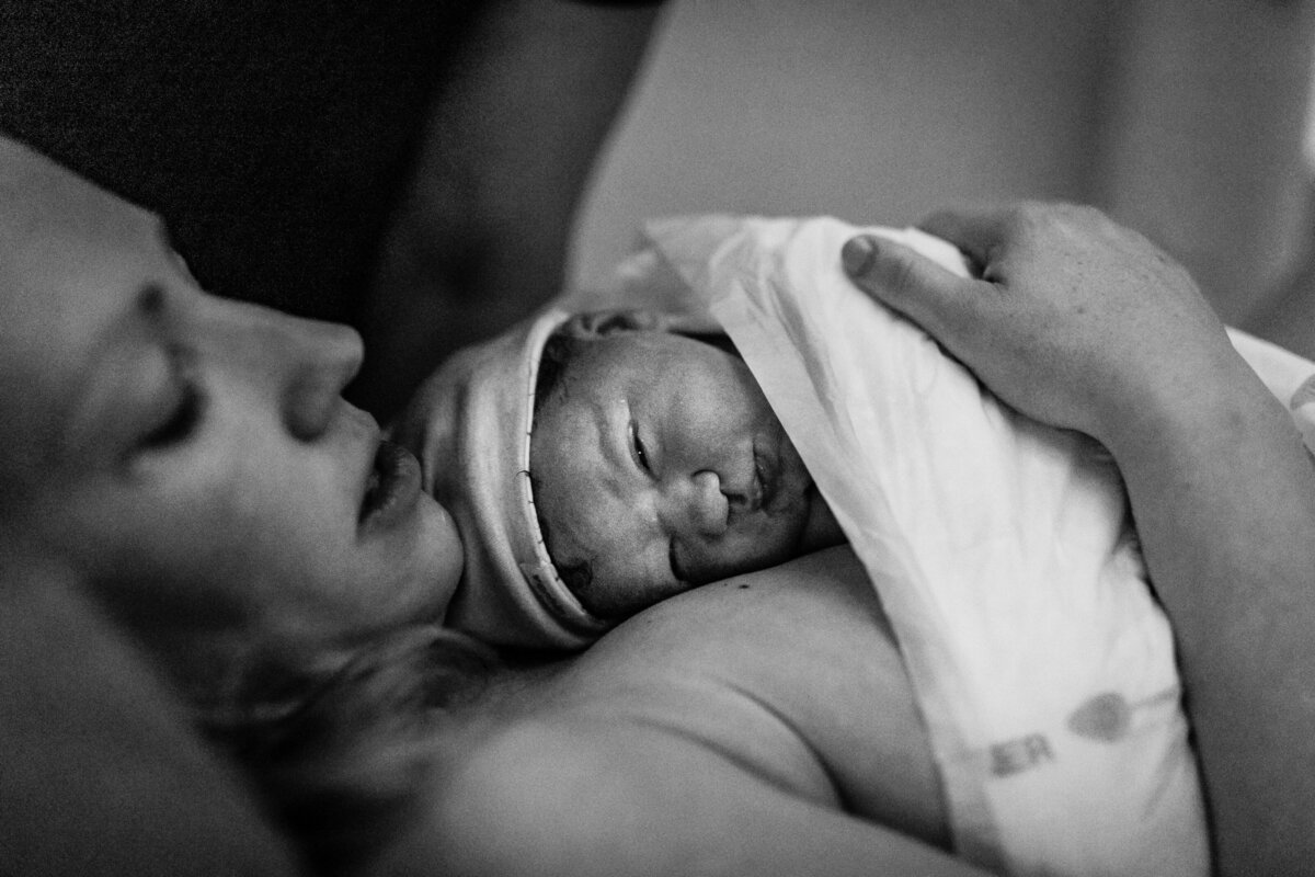 zwartwit foto van pasgeboren baby die bij moeder ligt
