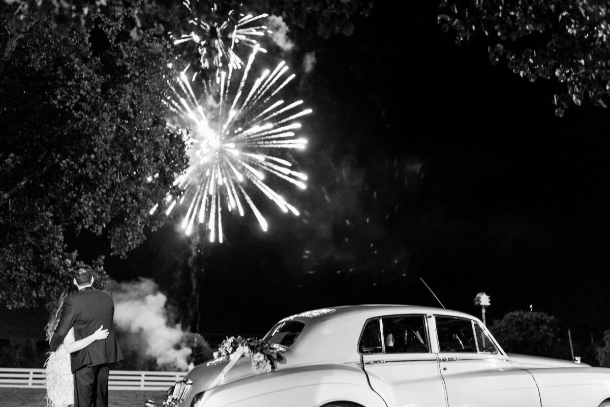 Bride and groom wedding exit with vintage Bentley and fireworks.