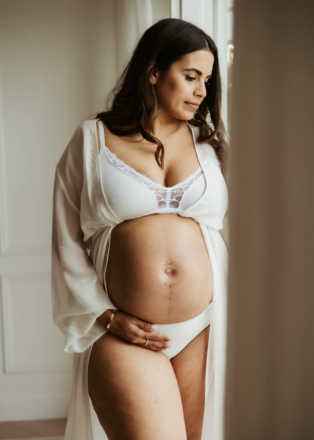 Sydney pregnant woman with black hair and wearing white underwear showing off her beautiful baby bump