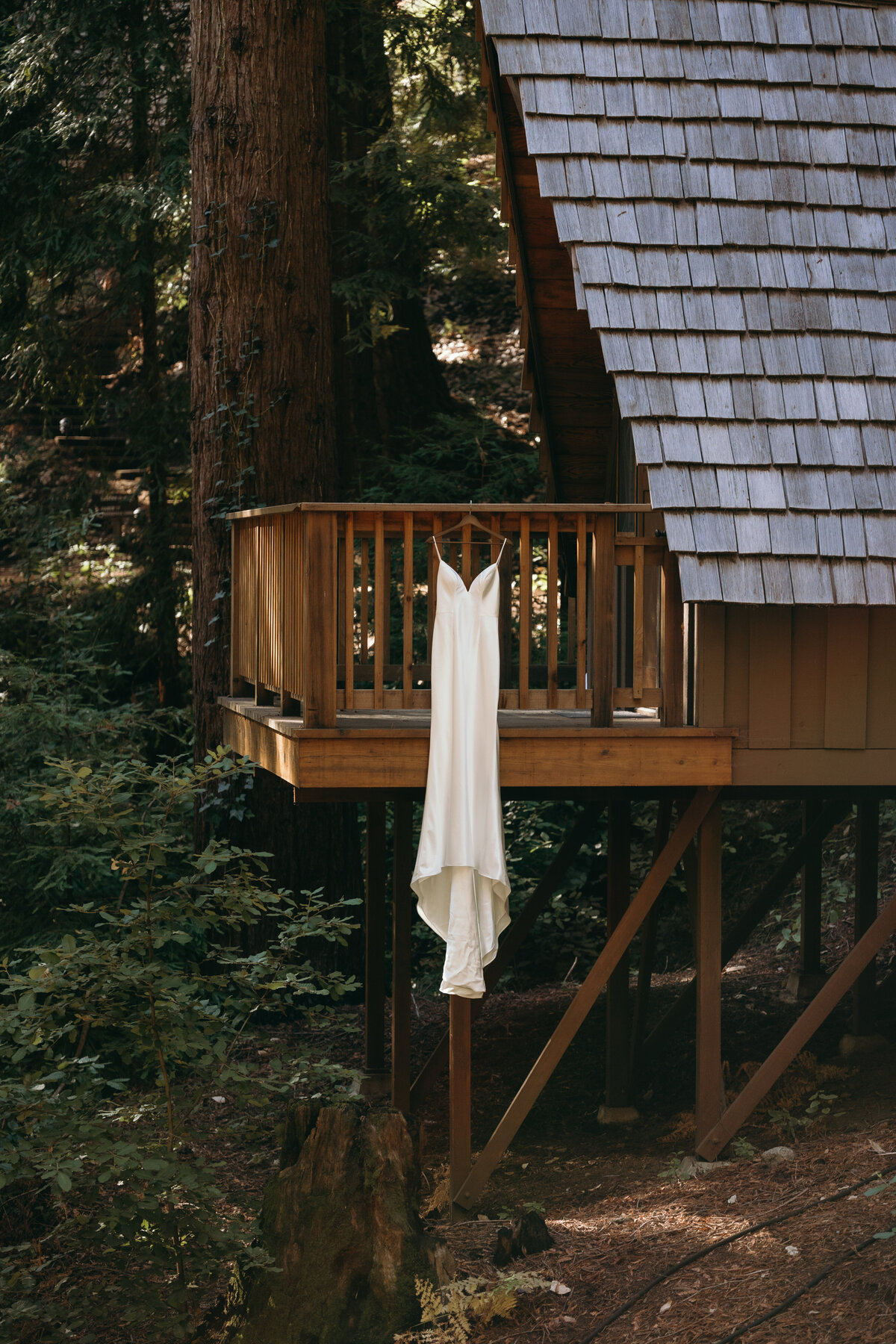 Brides dress hangs on dress in cabin at Waterfall lodge and retreat