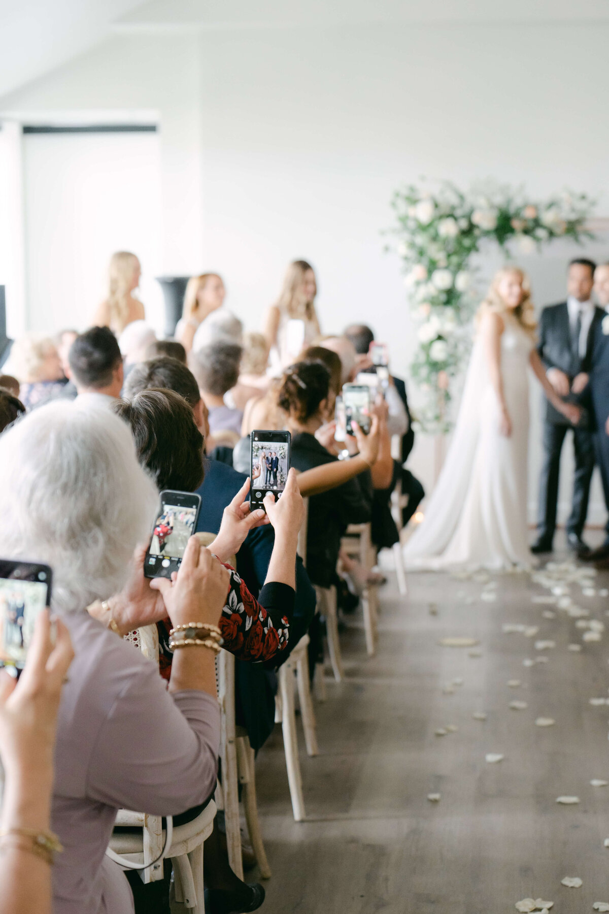 People use phones to photograph wedding.
