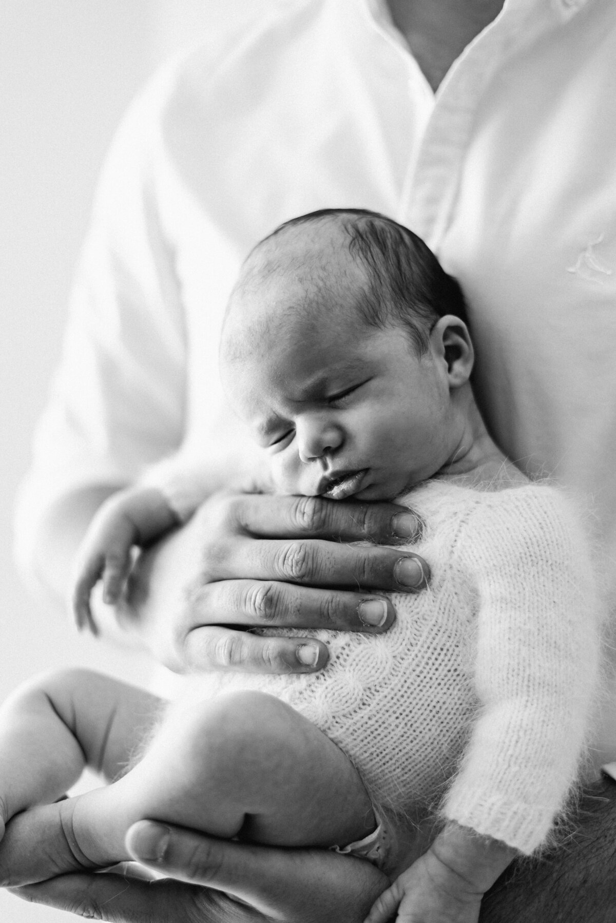 a father holding his baby daughter at billingshurst newborn photoshoot