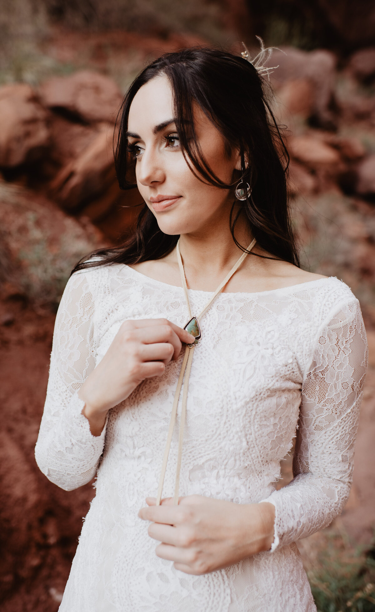 Utah Elopement Photographer capture bride putting on western necklace