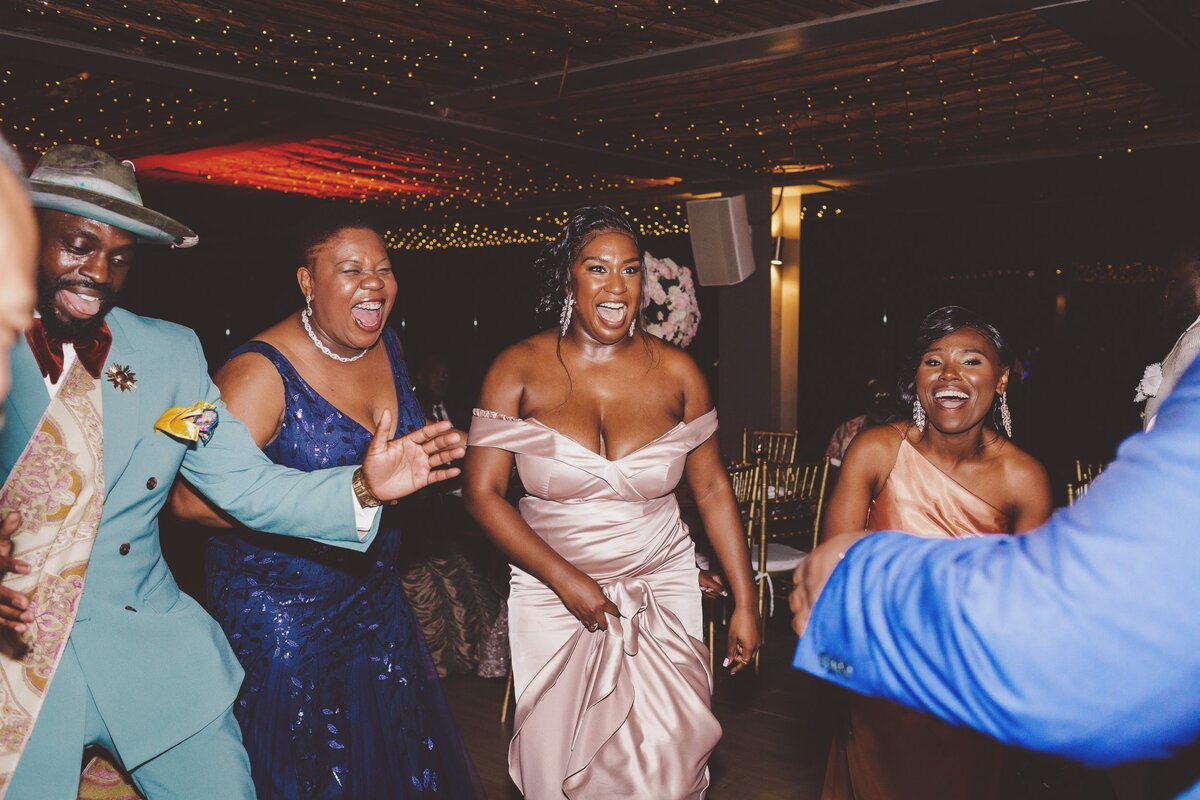 Guest and bridesmaid laughing and dancing.