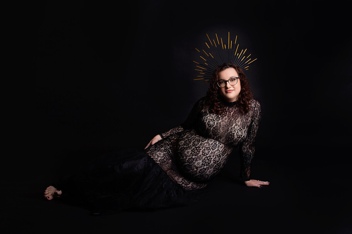 Women wearing black lace gown and goddess crown during maternity photoshoot in Mount Juliet Tennessee photography studio