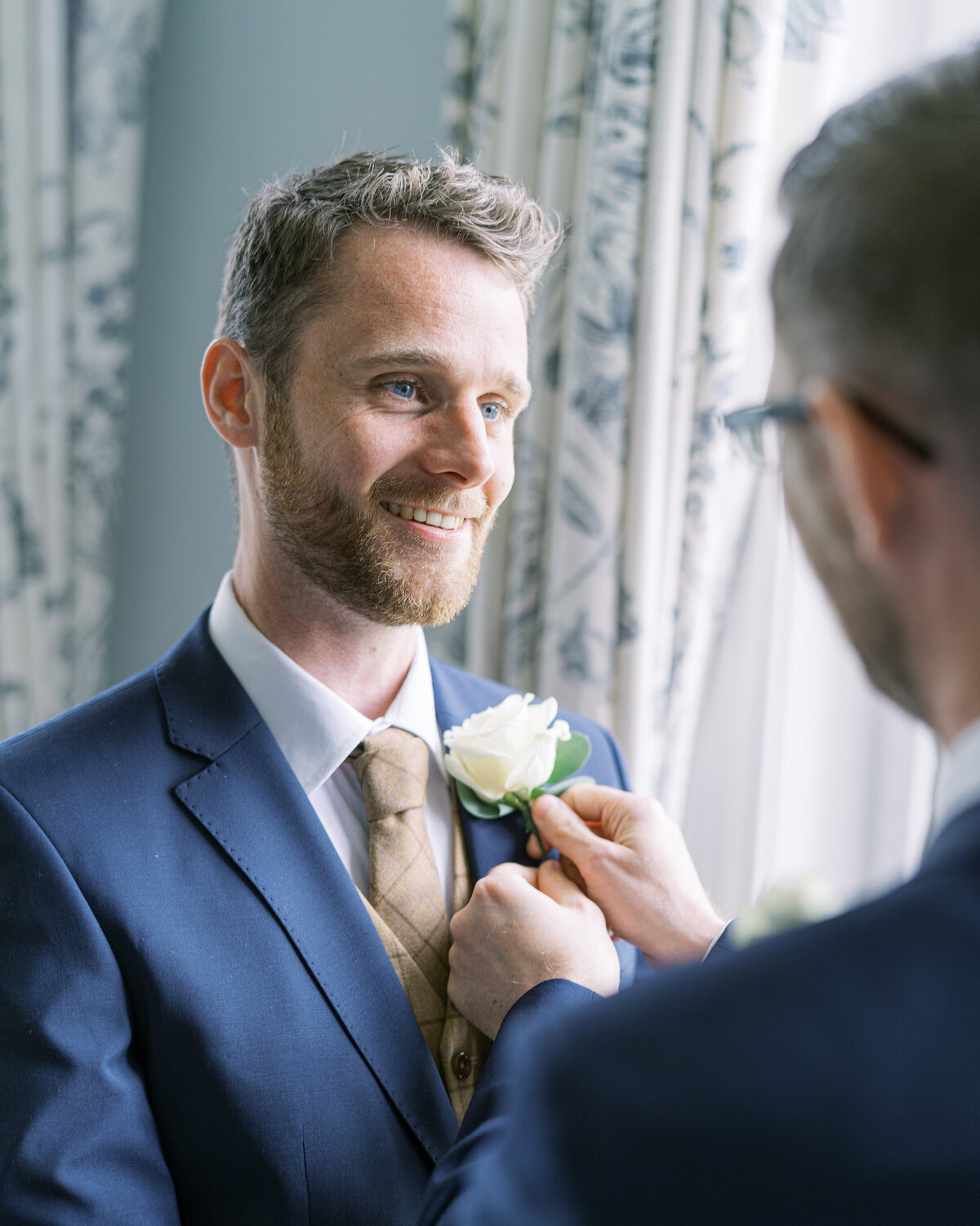 Groom wearing buttonhole in country estate wedding