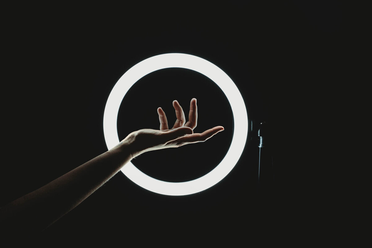 delicate fingers posing in front of a ring light
