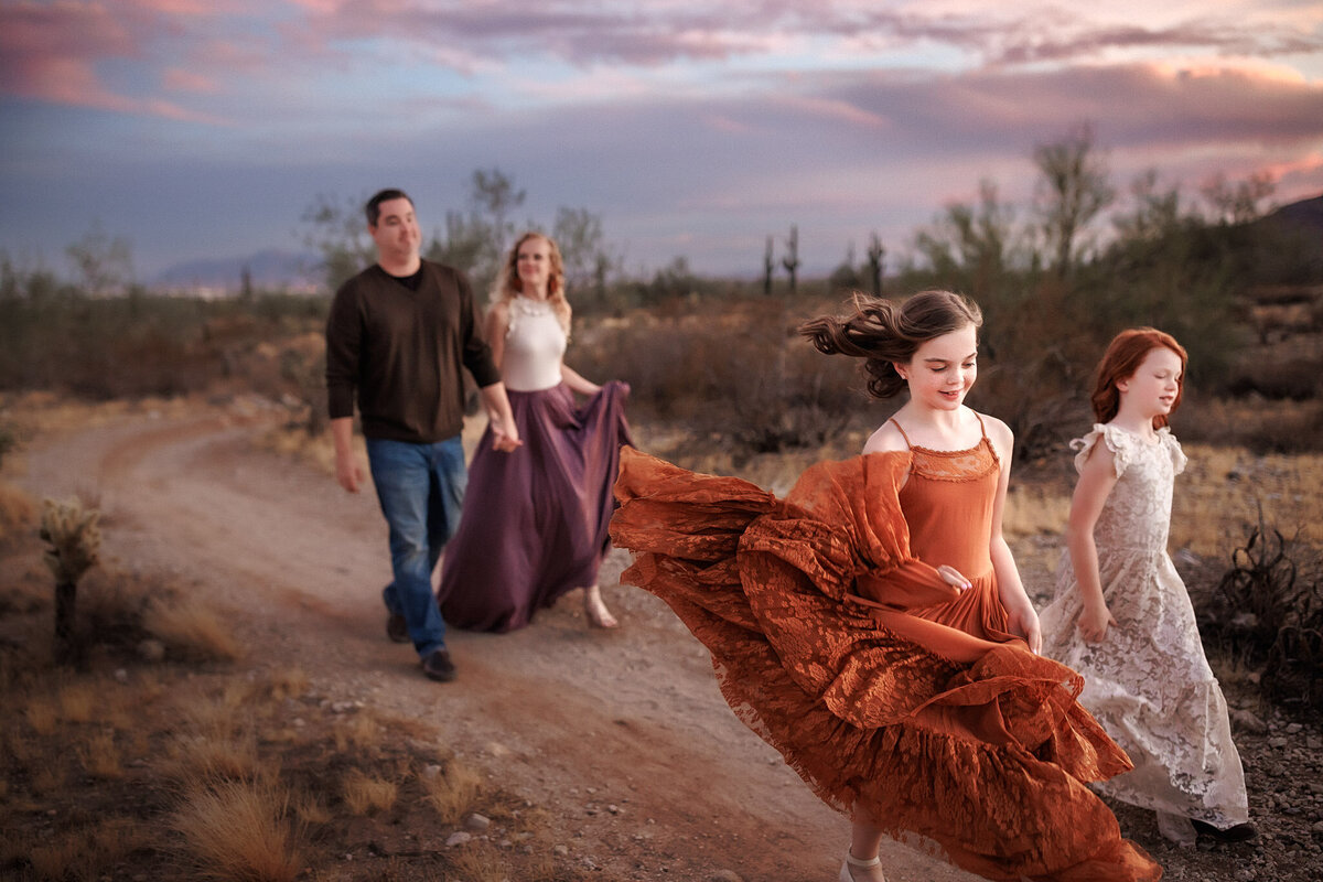 family skipping through arizona desert in dresses