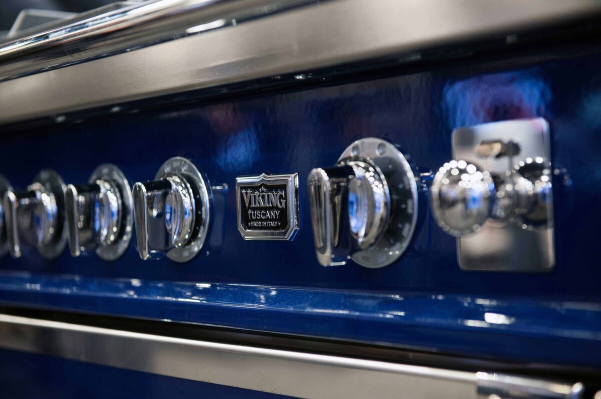 A closeup photo of viking tuscany stove knobs on blue stove