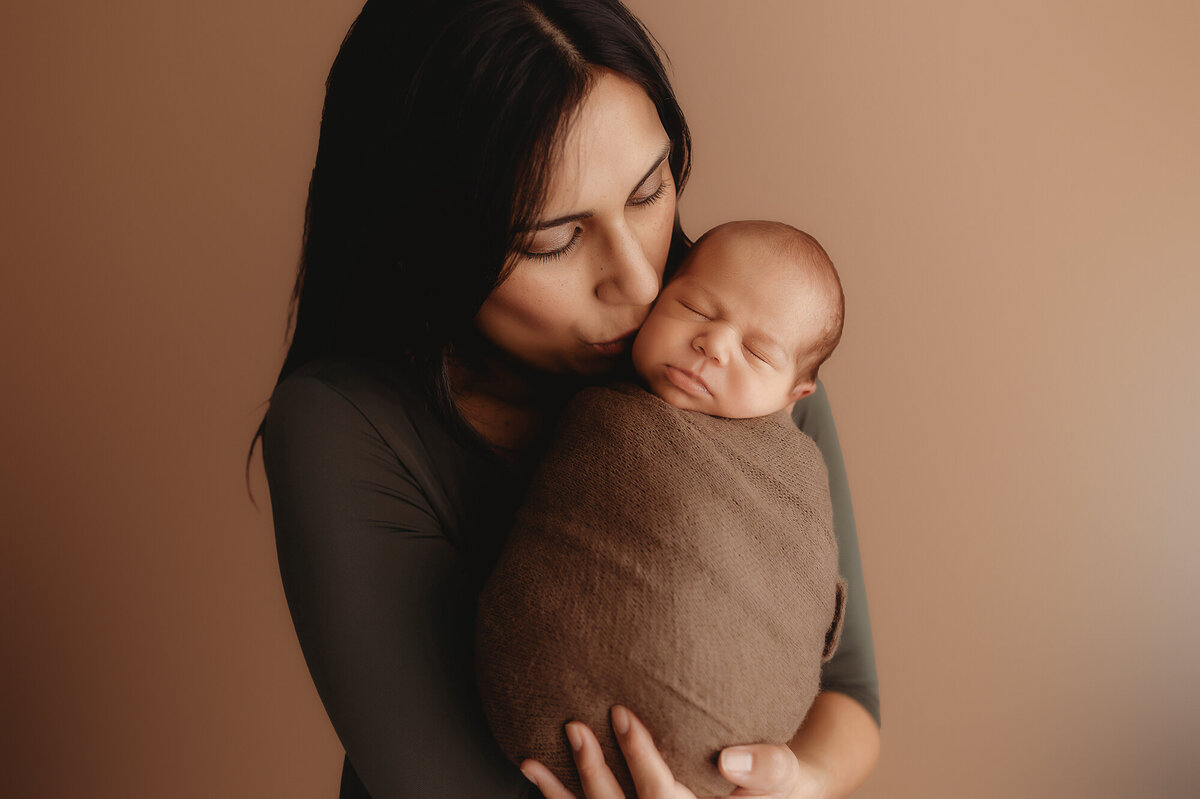 Mother embraces her infant during Newborn Photoshoot in Asheville.