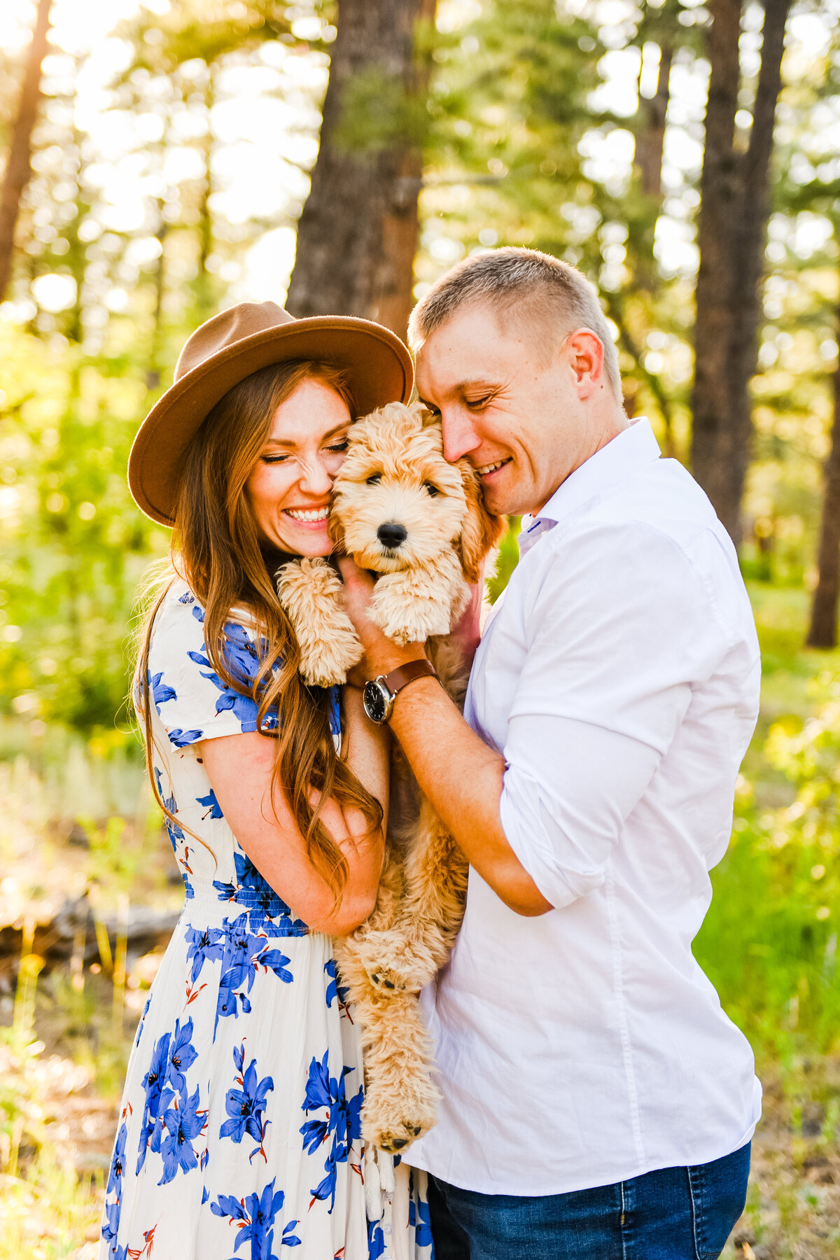 Couple holding golden doodle puppy golden hour engagement pine trees Flagstaff