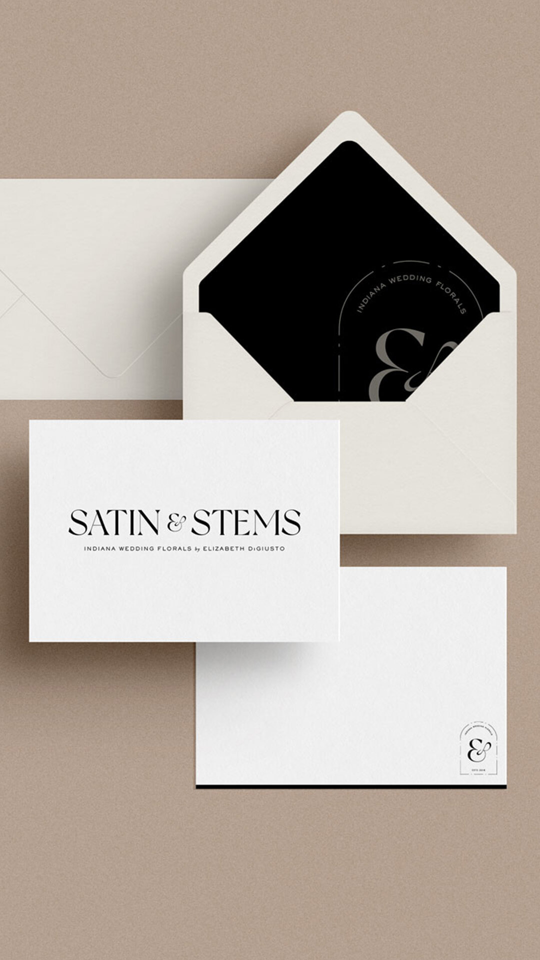 a mockup showing classic branding on black, white, and neutral stationery