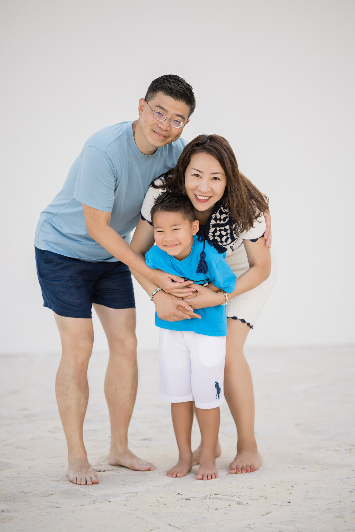 Parents crouching down hugging their child