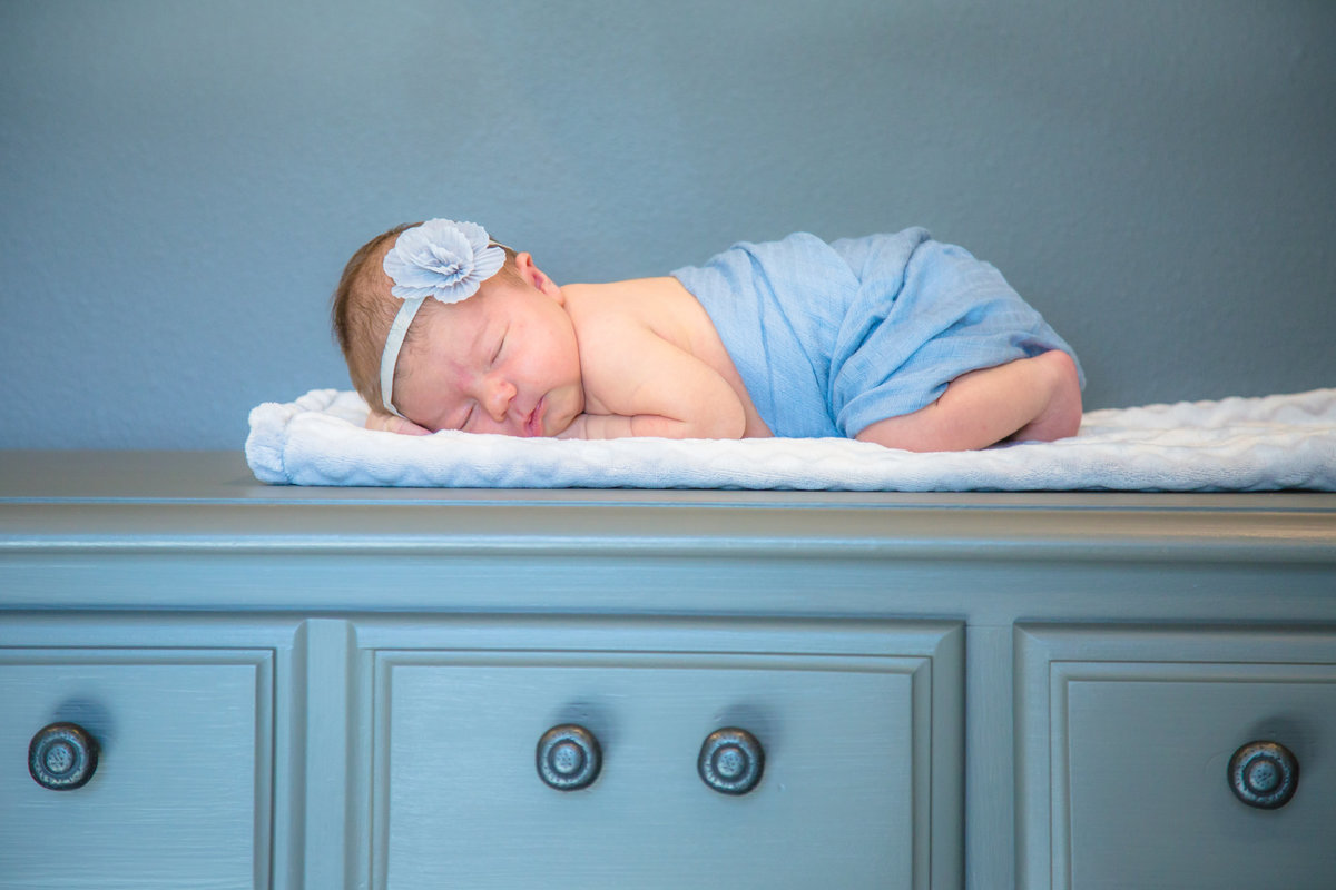 Newborn baby sleeping on her dresser