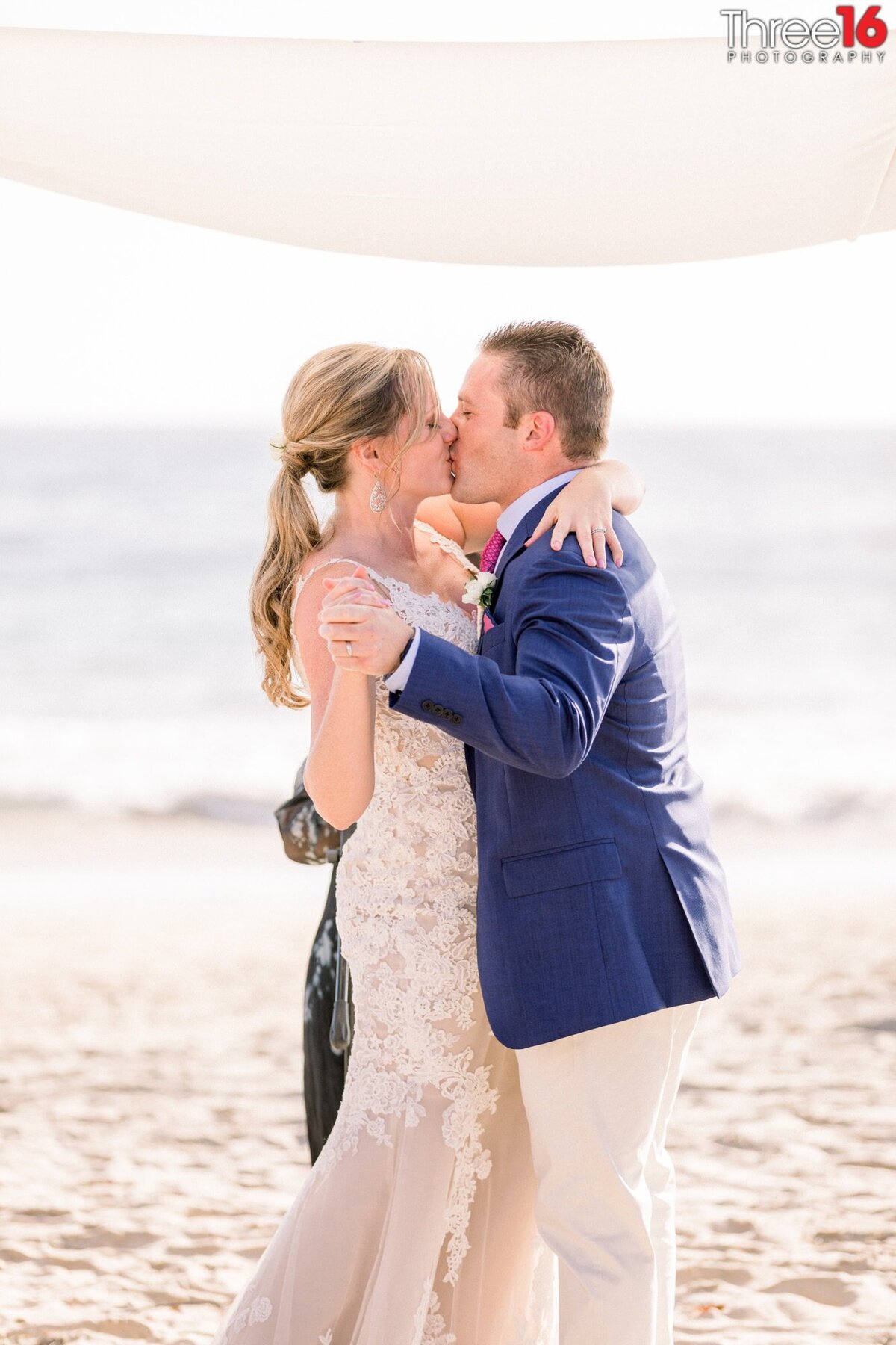 Bride and Groom share their first kiss while standing under the Chuppah