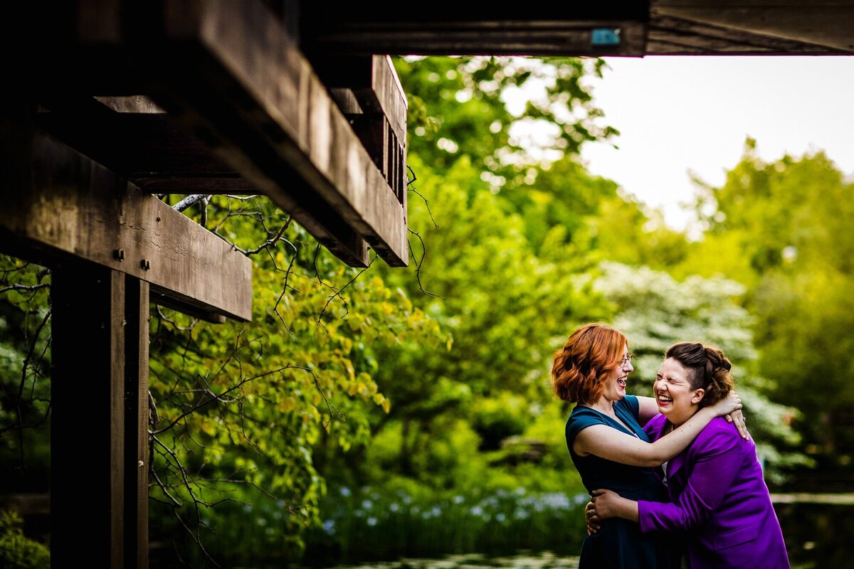 A couple laughs together during a Caldwell Lily Pond engagement session.