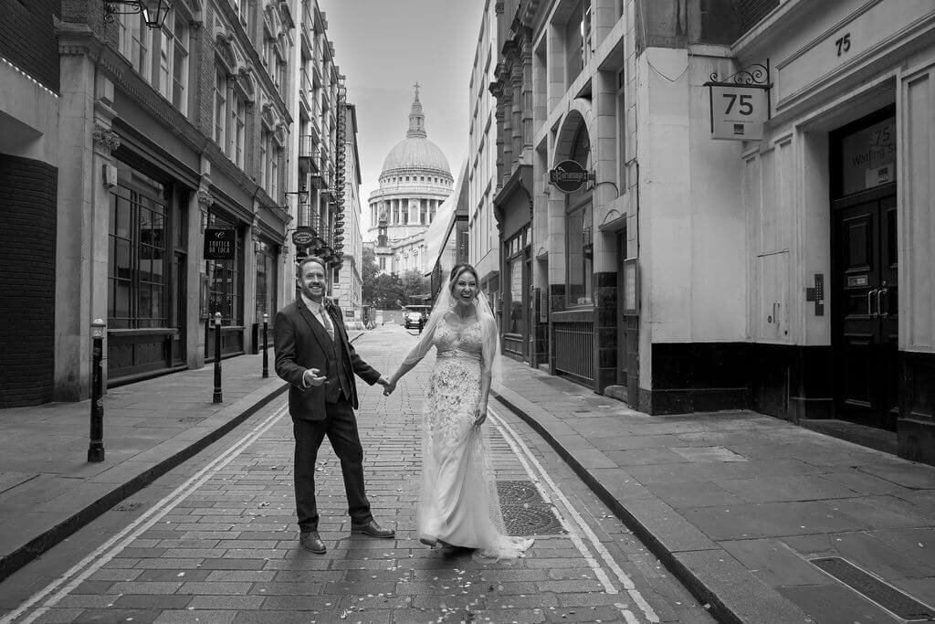 Bride and groom hand in hand in London street