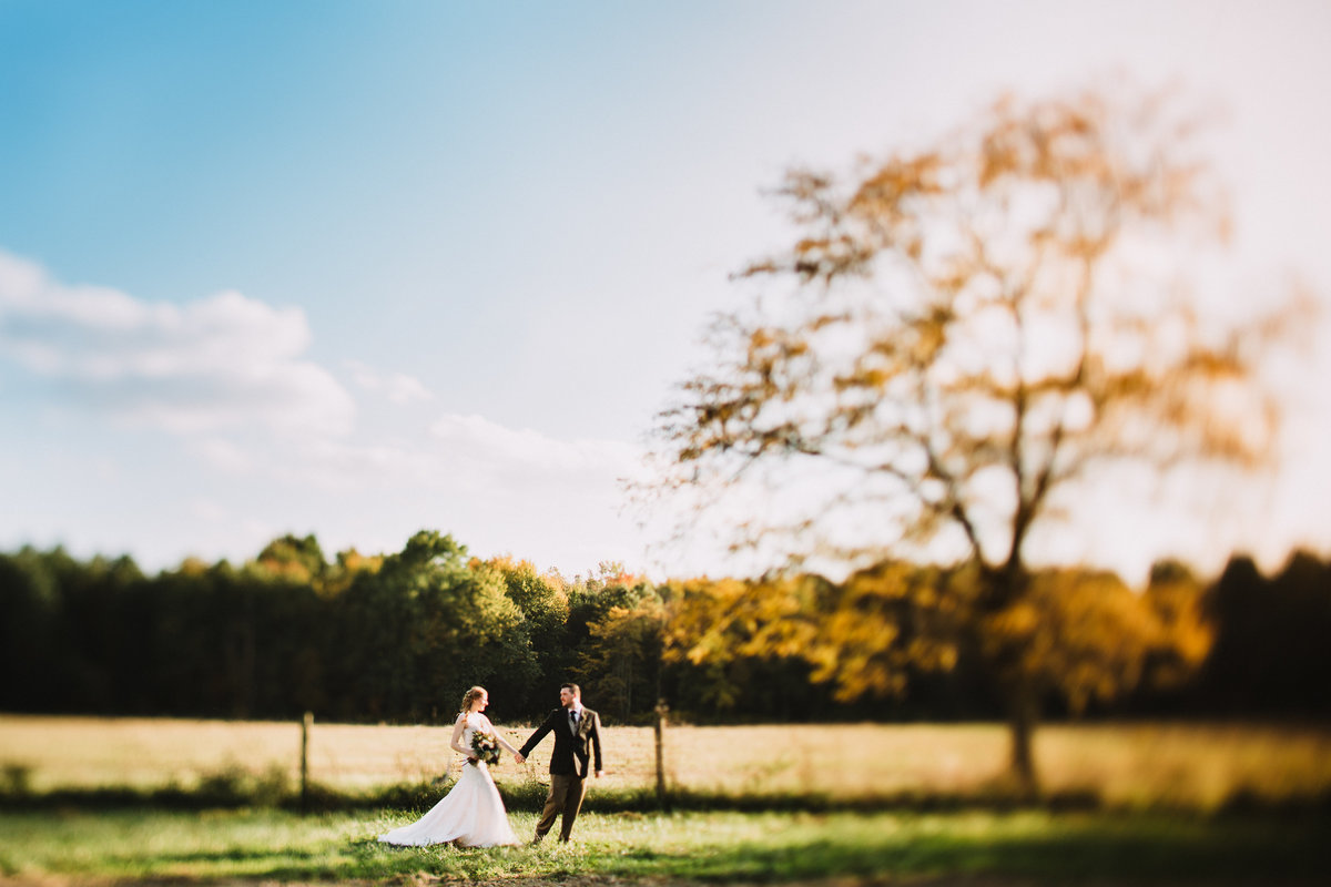 a photo of a couple running through the countryside at Jorgensen Farms