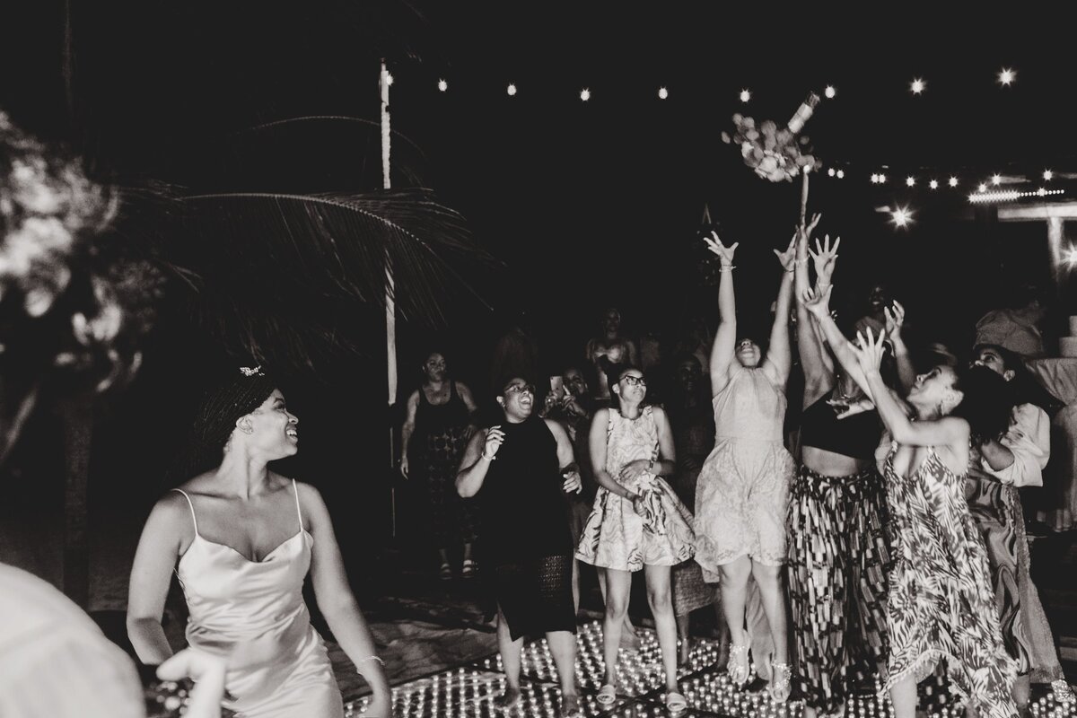 Bride tossing bouquet at wedding in Cancun