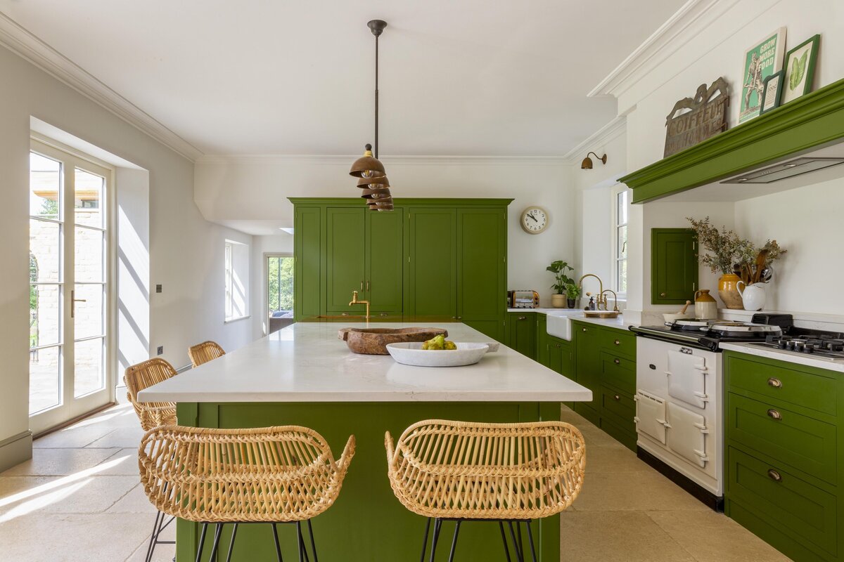 Green cabinetry with wicker chairs modern and artwork on shelves