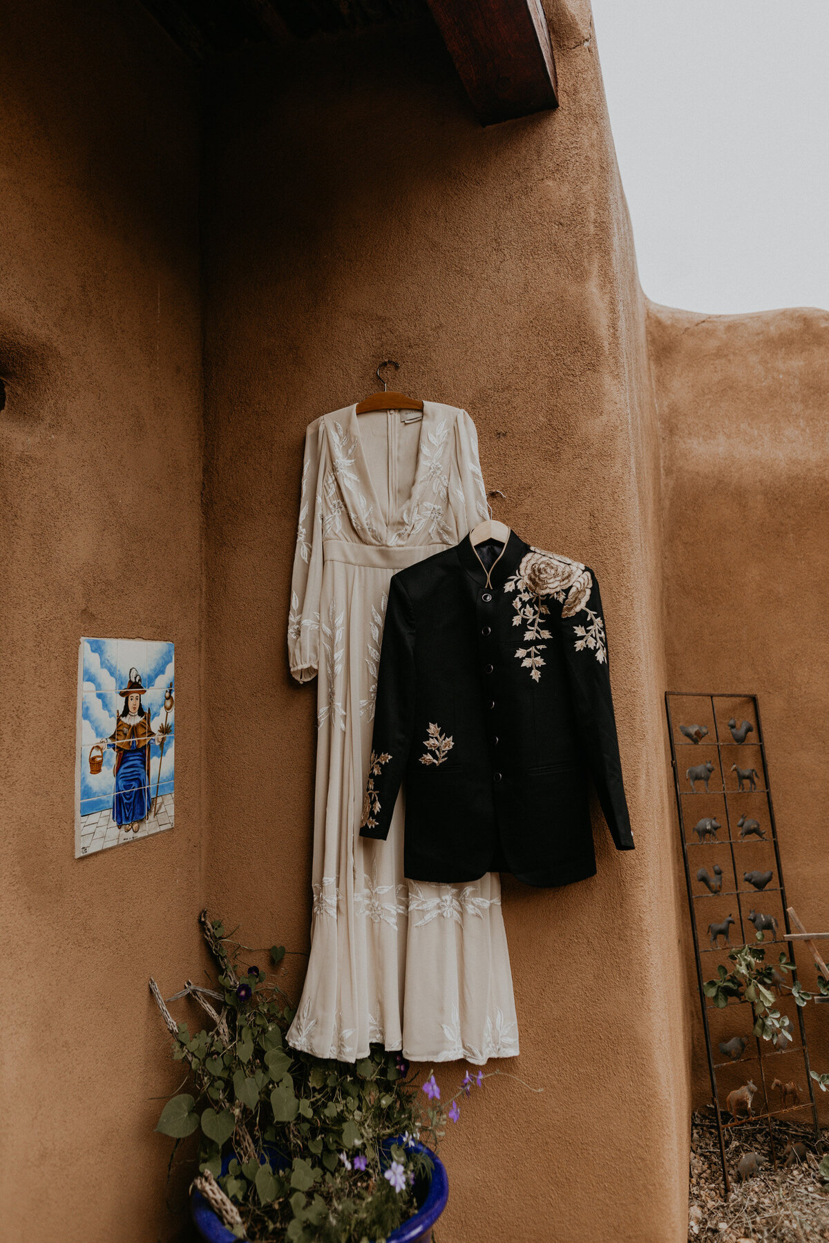wedding gown and Indian suit hanging on an adobe home