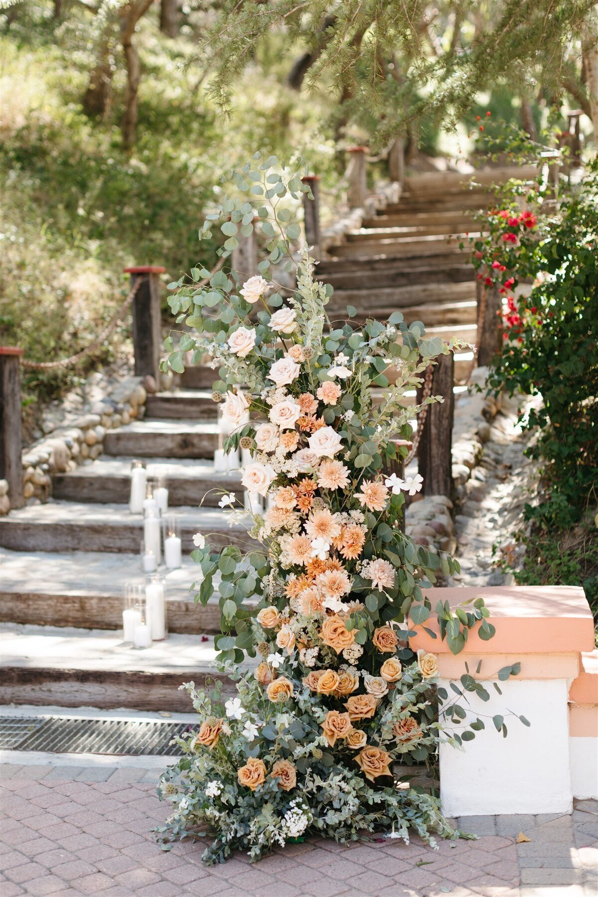Wedding ceremony floral pillar with peach and brown roses