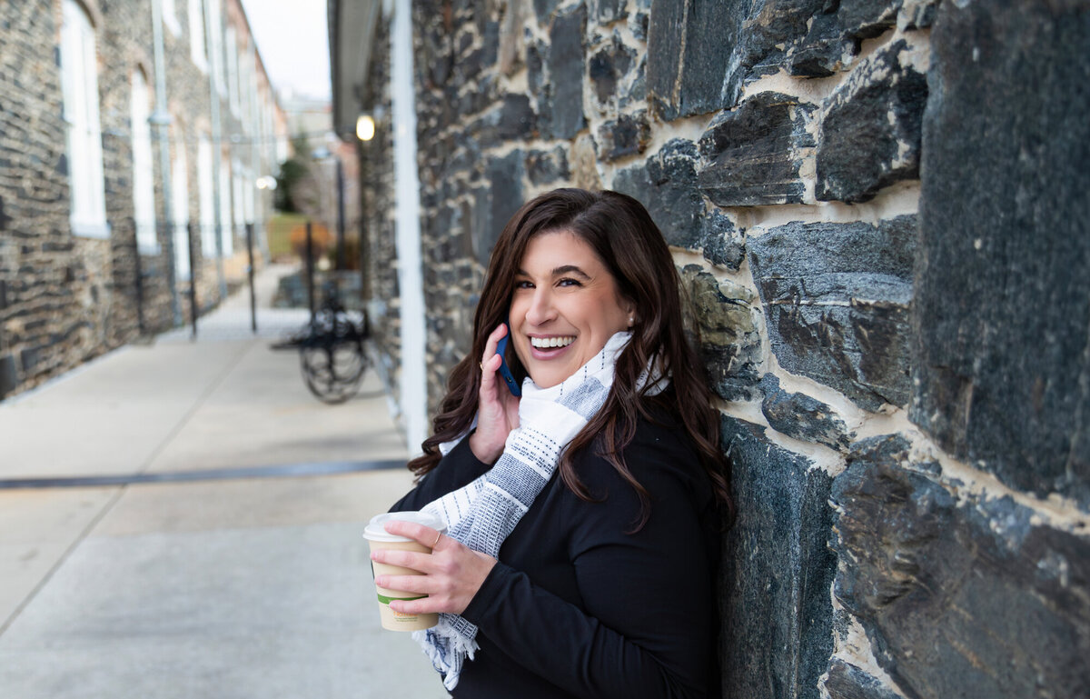 An-entrepreneur-smiles-and-laughs-during-her-branding-photoshoot-with-Ingrid-Berrios-Photography-in-Baltimore-Maryland-at-Artifact-Coffee.