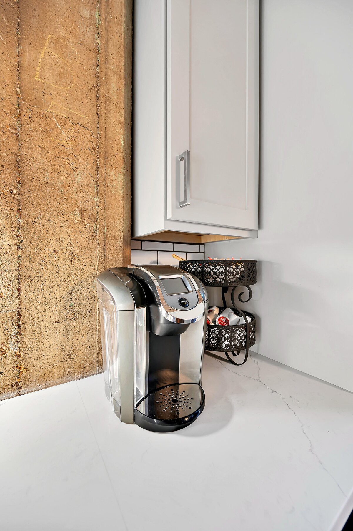 Keurig coffee maker with coffee pods in the fully stocked kitchen of this one-bedroom, one-bathroom vintage industrial condo with Smart TV, free Wi-Fi, and washer/dryer located in downtown Waco, TX.