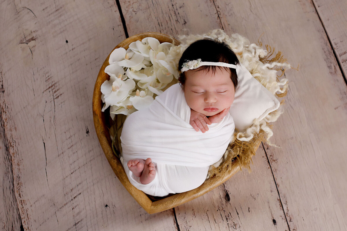 Newborn-photography-session-newborn-in-basket-with-flowers,-photo-taken-by-Janina-Botha-photographer-in-Oakville-Ontario