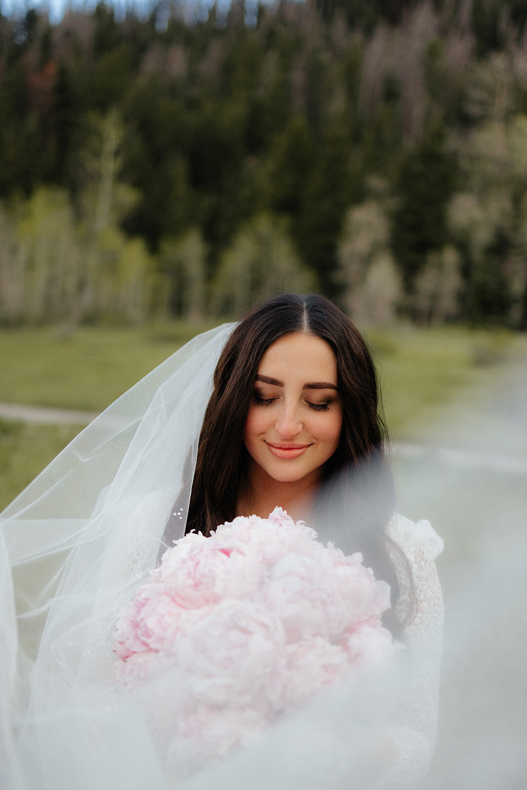 Utah mountain bridal shoot with bride holding pink peonies bouquet.