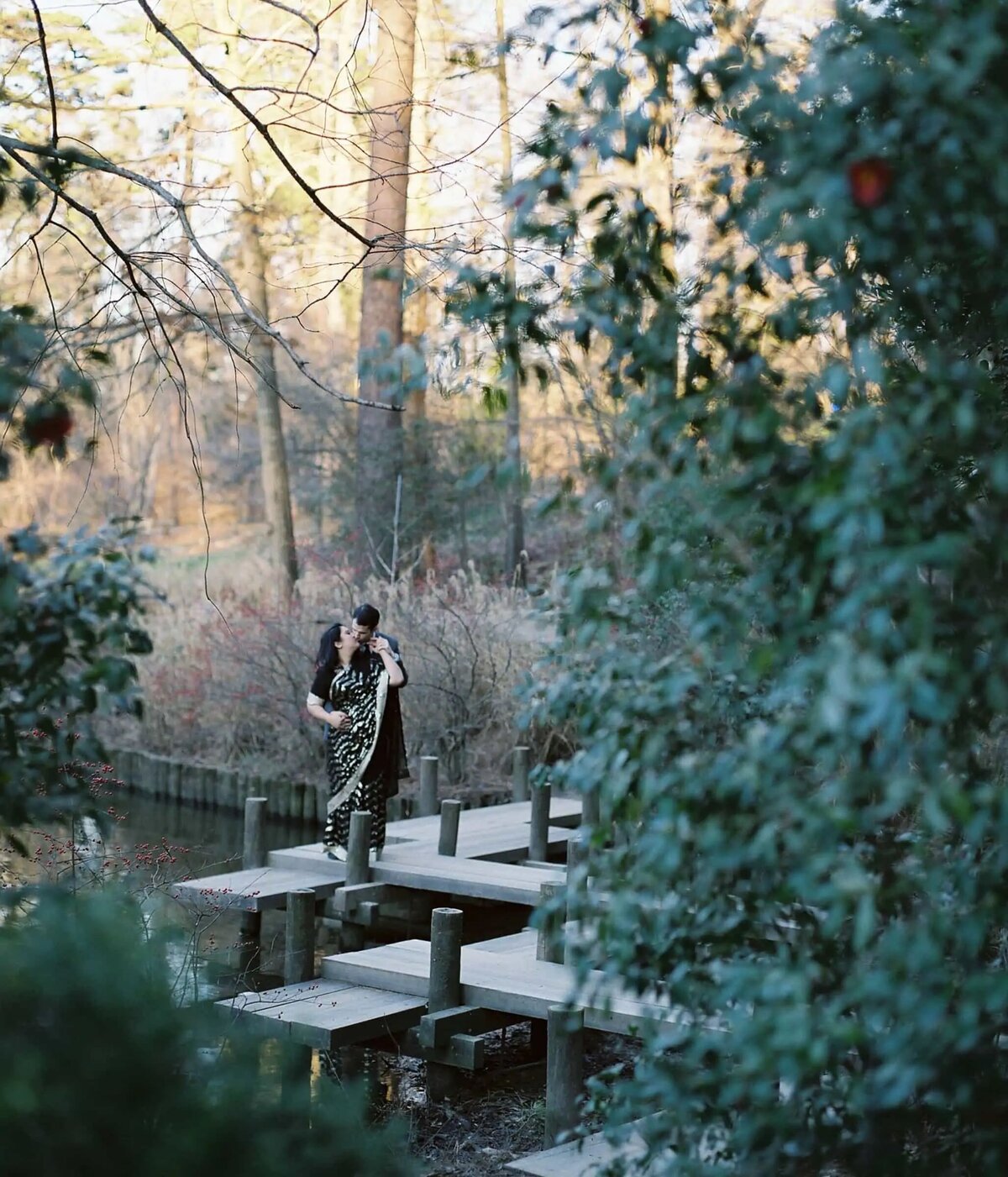 A romantic scene with a couple embracing on a wooden bridge in a serene woodland area