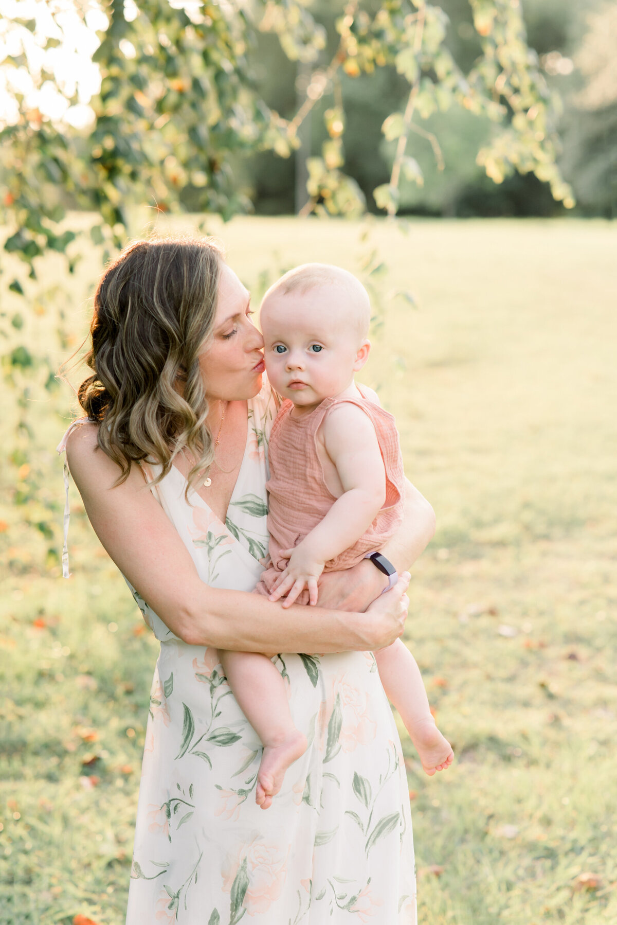 a mom kissing her baby on the head