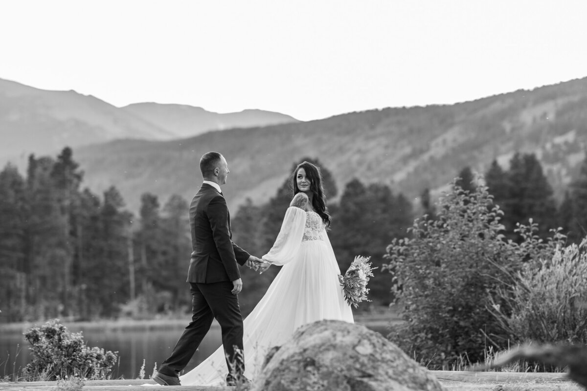 Bride leading groom in front of the mountains at sprague lake, rocky mountain national park