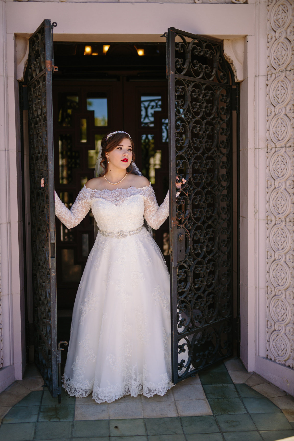 Bride opening the gate at McNay Art Museum in San Antonio posing for a picture by Expose The Heart Wedding Photography