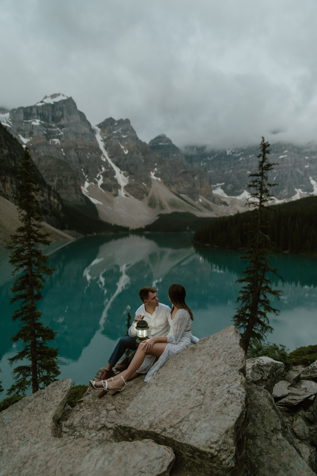 couple taking in the sunrise from latern at Moraine Lake, Alberta