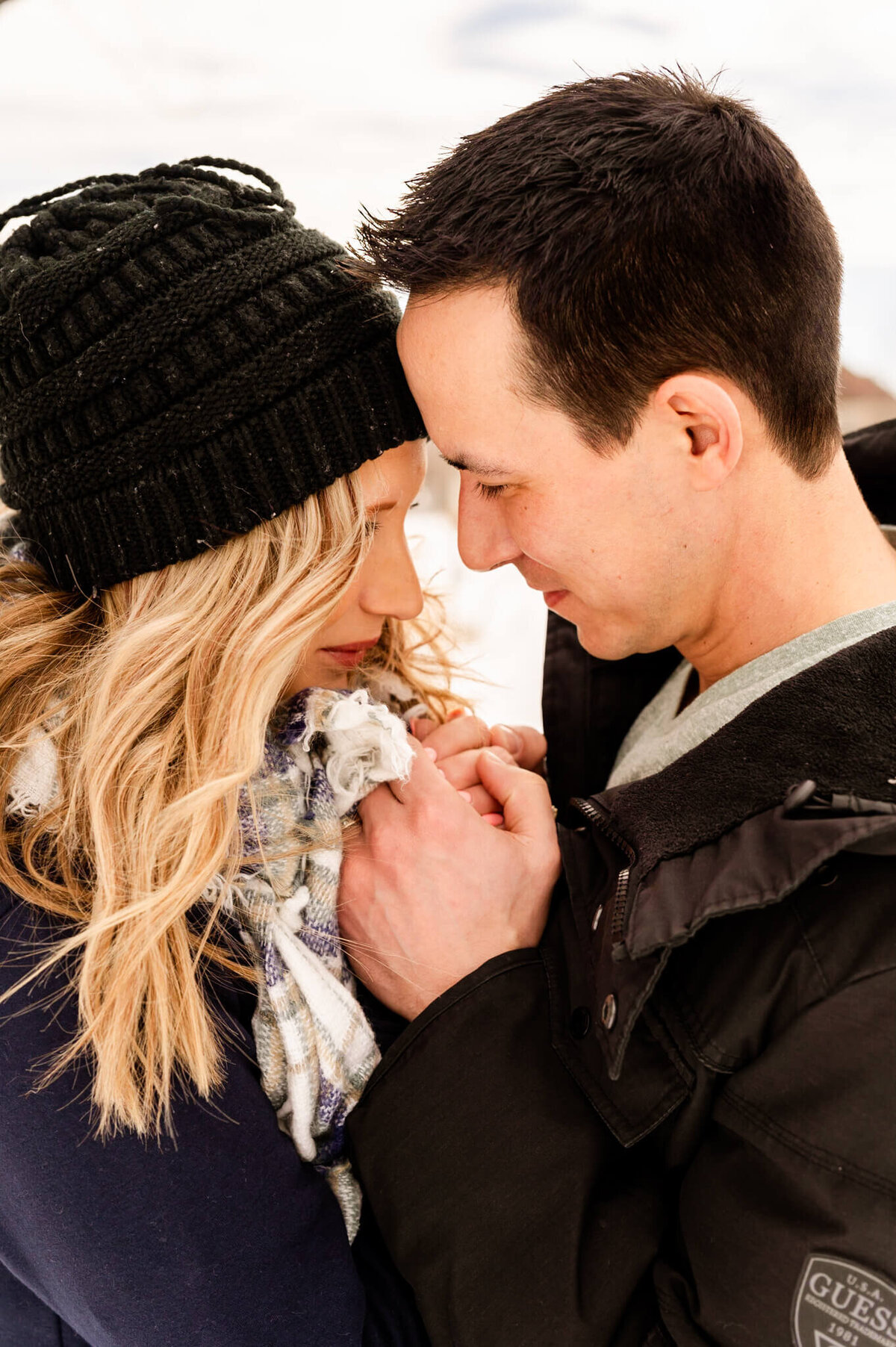 Man and woman warm each other up in the snow during a couples session near Chicago, IL.
