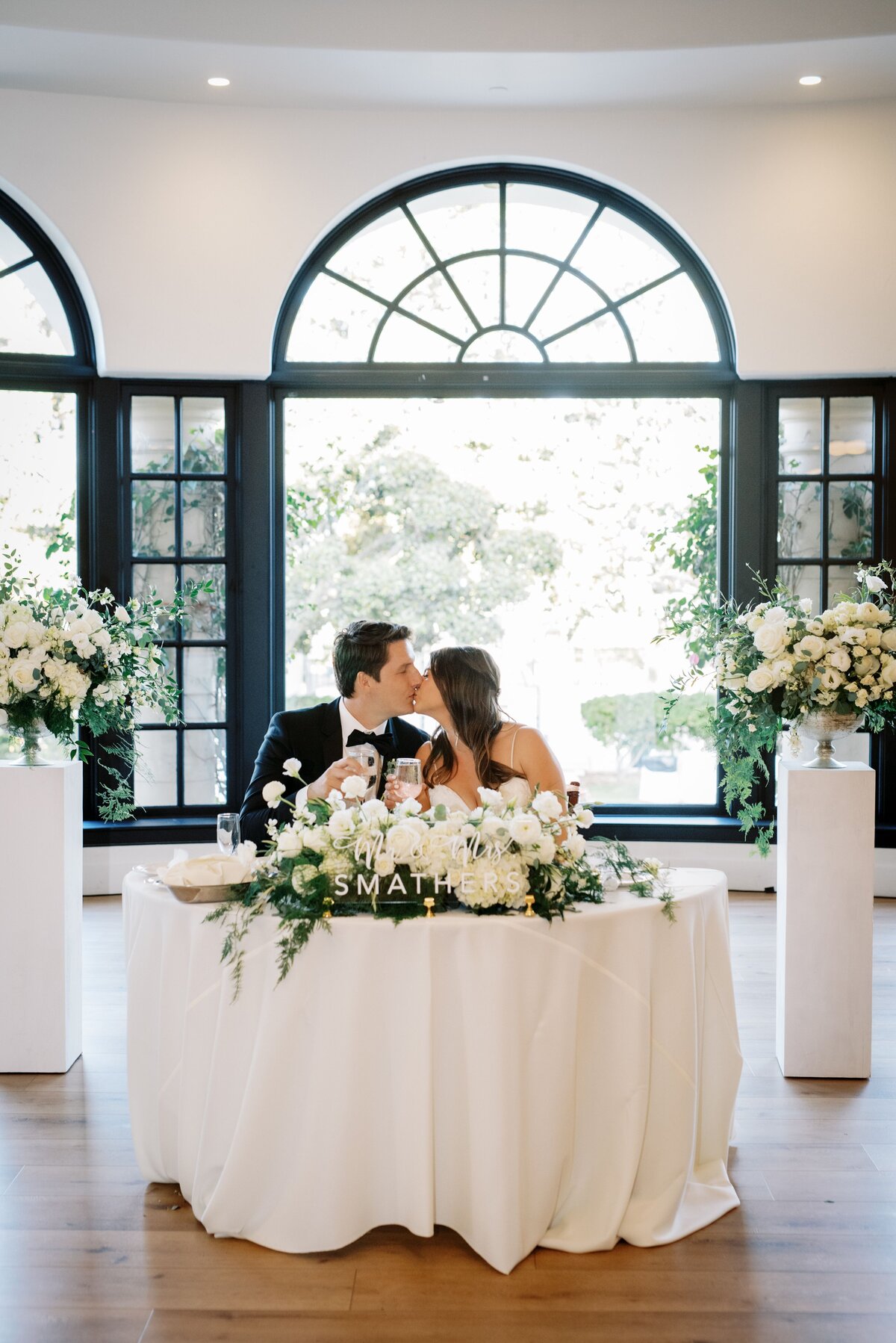 The bridal dining table is framed with large bouquets to make them known during the dinner.
