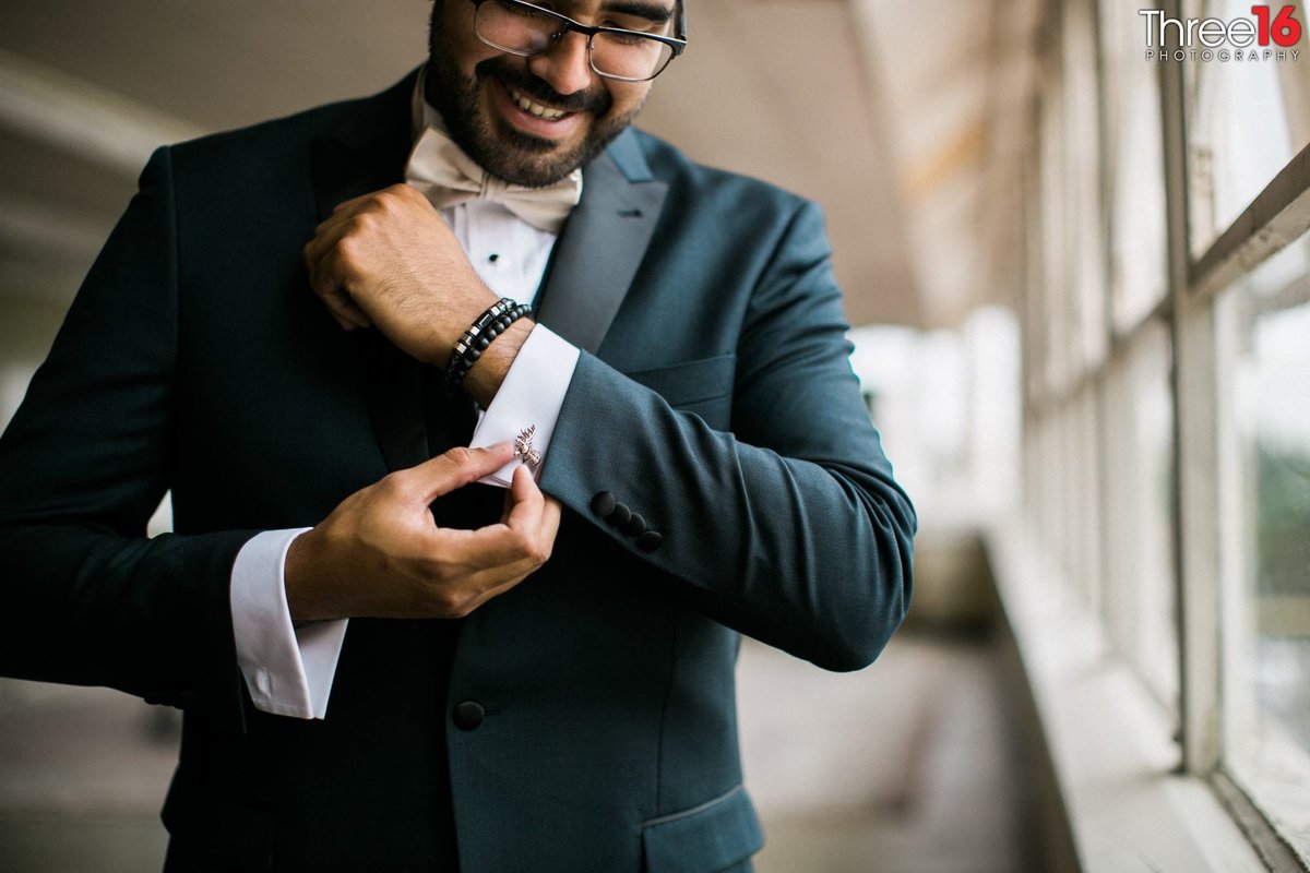 Groom adjusts his cuff links prior to his wedding