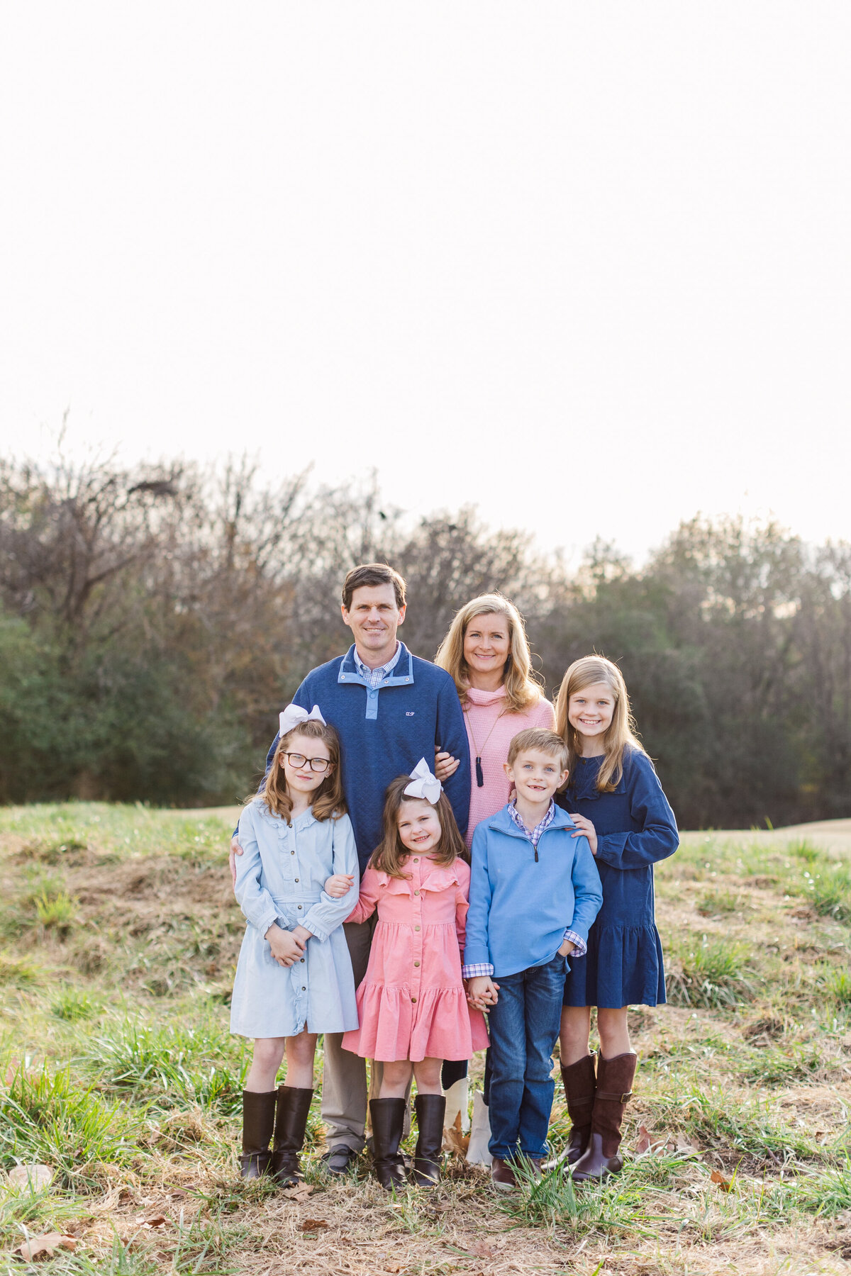 family posing in a field for winter photo session