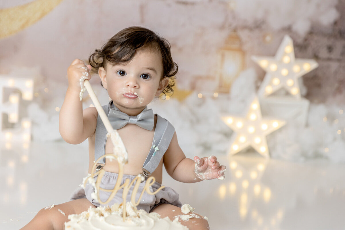 Little boy celebrates his first birthday with a star themed cake smash
