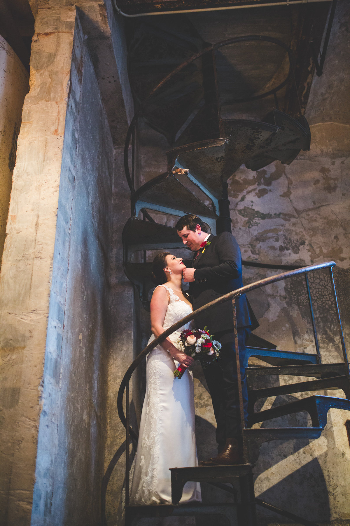 Bride and groom standing on a spiral staircase at the Hotel Emma San Antonio wedding venue