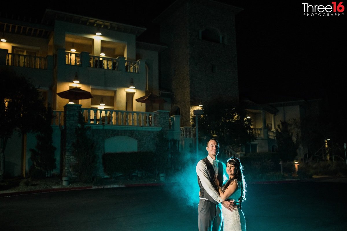 Bride and Groom pose together at night with special effect in background