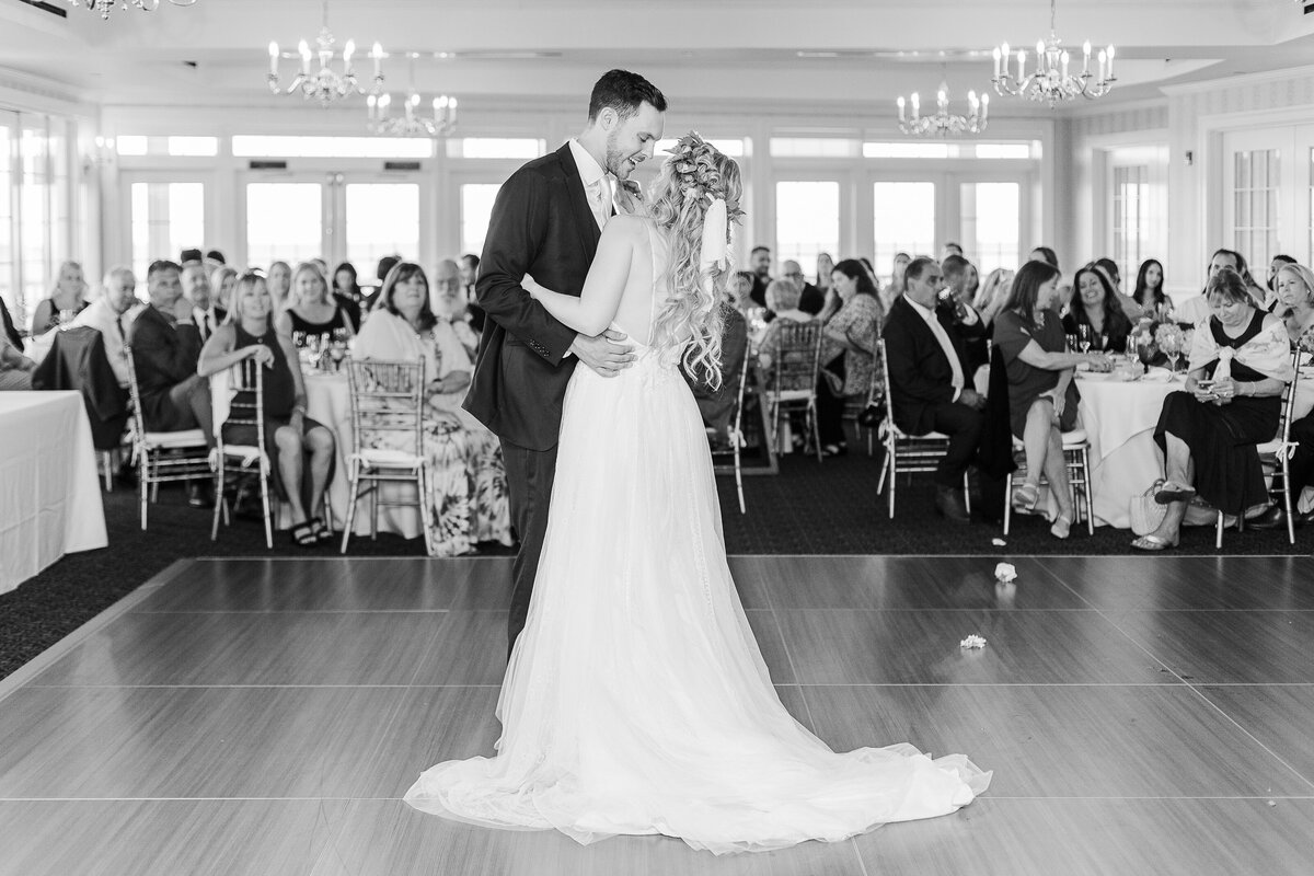 Bride and groom share a kiss after their first dance at their Madison Beach Hotel wedding reception. Captured by best New England wedding photographer Lia Rose Weddings.
