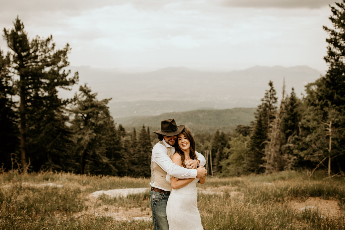 groom holding bride from bahind at Sandia Peak in Albuquerque
