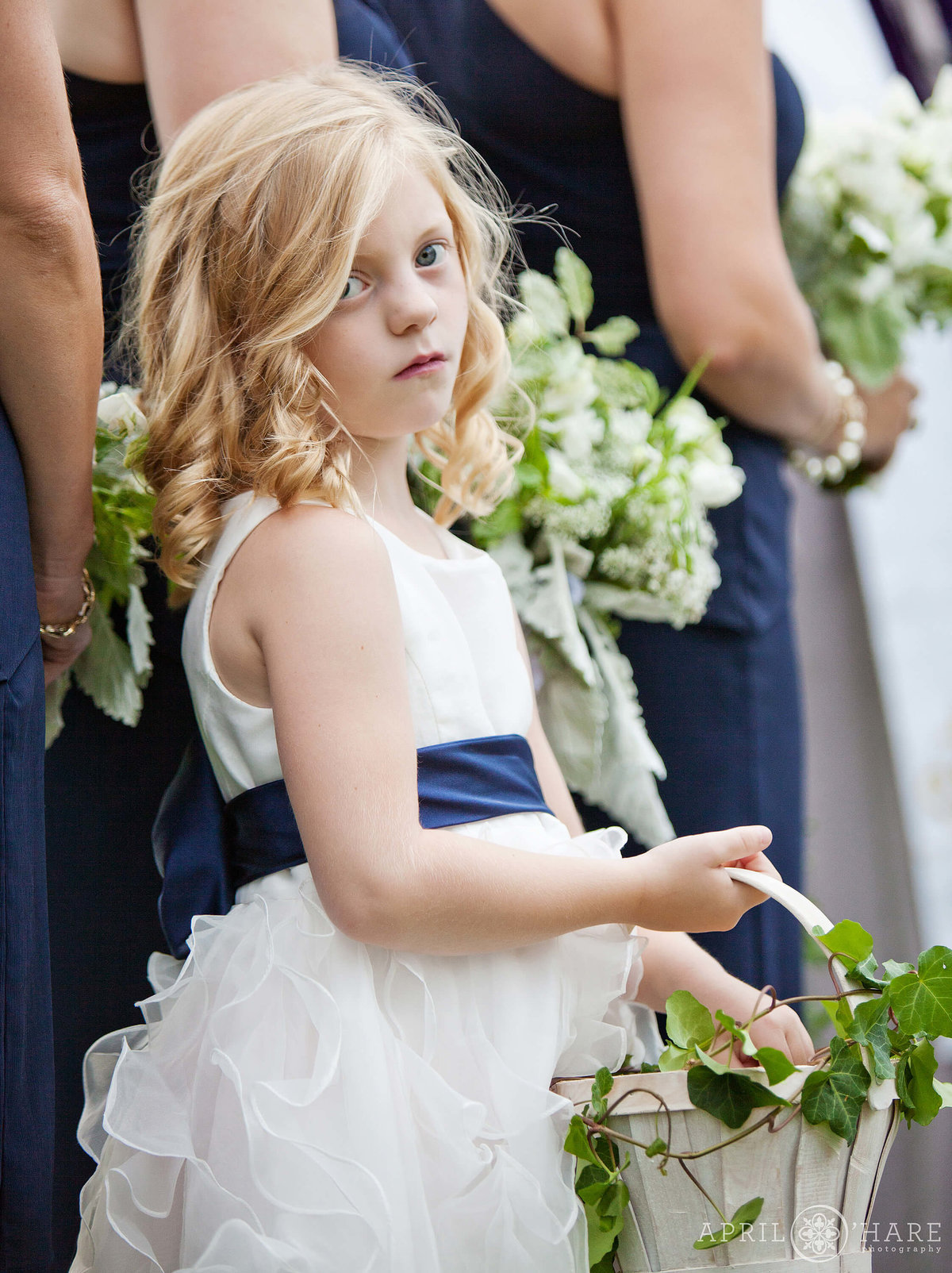 Serious flower girl during outdoor wedding ceremony in Boulder Colorado