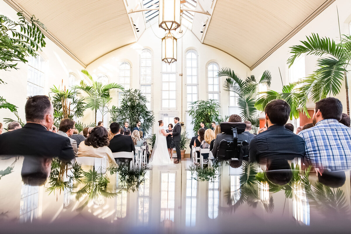 Creative reflection of bride and groom during their wedding ceremony at Piper Palm House