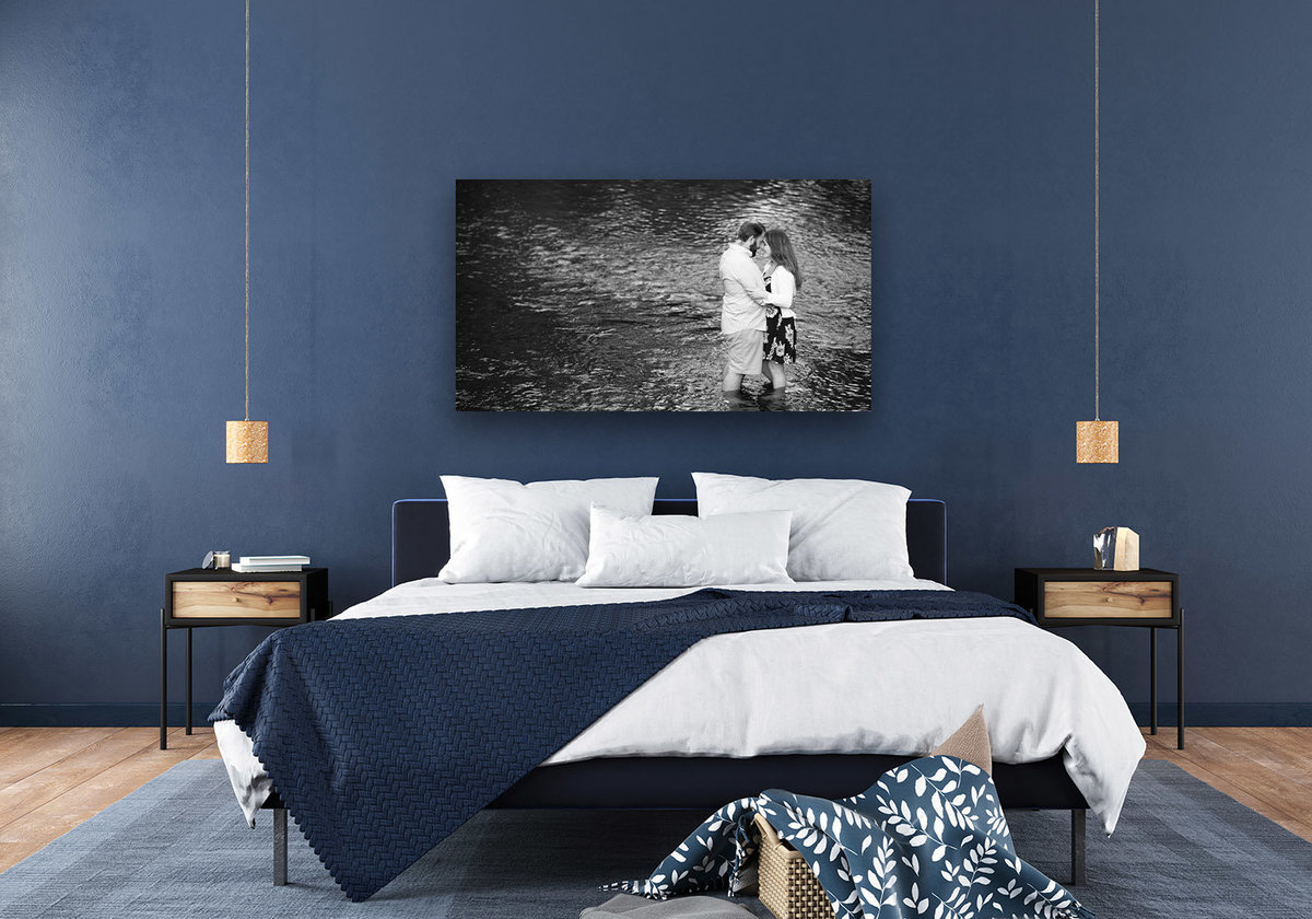 Wide fine-art print on a blue wall above the bed frame.