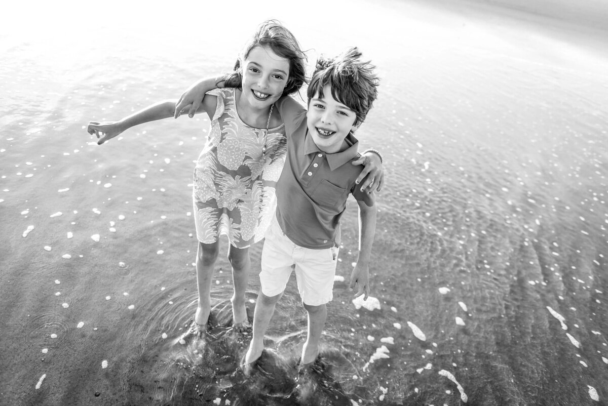 A pair of young siblings standing in the water in Ocean City, New Jersey