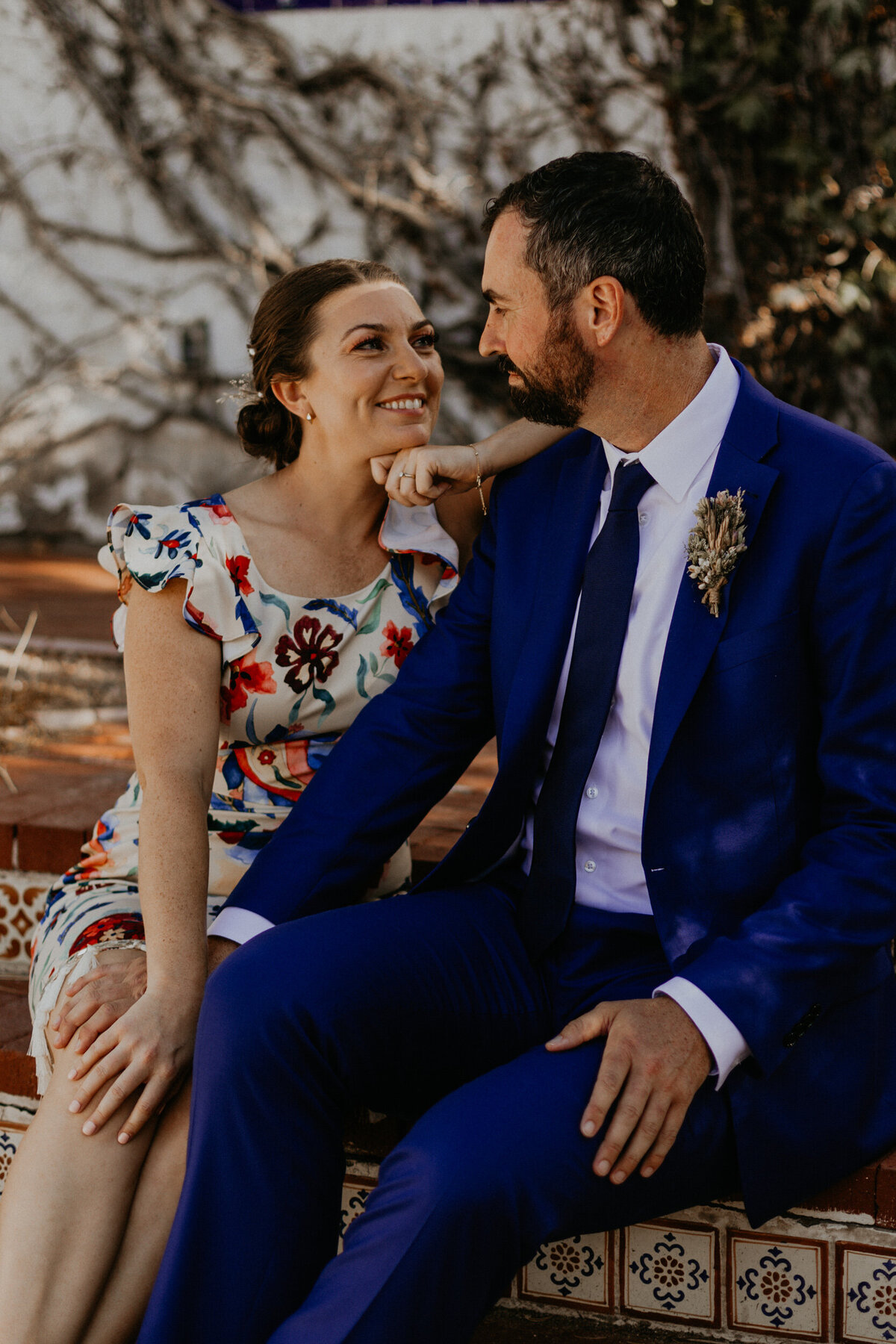 newlyweds sitting together on a colorful tiled staircase in Santa Fe
